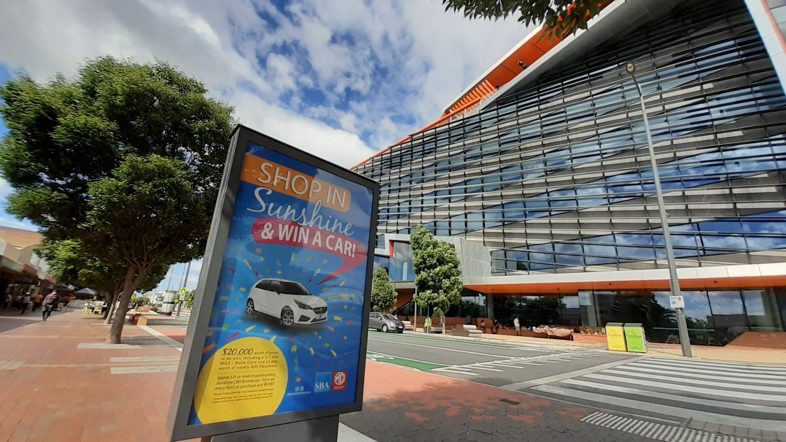 Photo of an Advertising board in the main street of Sunshine with the Council office building in the background